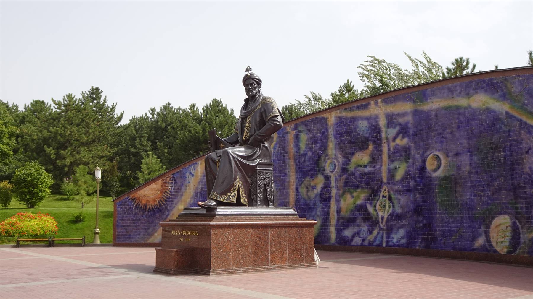 Statua di Ulugh Beg davanti al murale astronomico a Samarcanda
