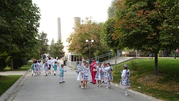 Bambini in costume danzano lungo il viale alberato di Tashkent