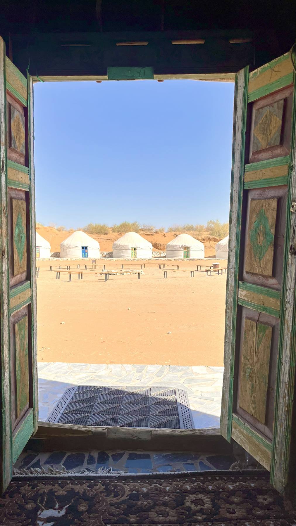 Porta in legno verde dipinta apre sulle iurte bianche del deserto