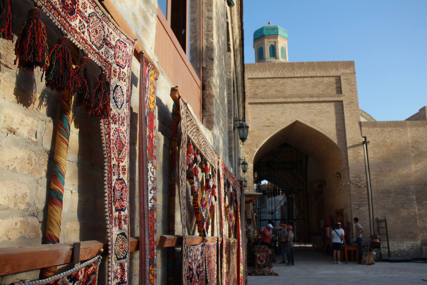 Tappeti appesi in un bazar di mattoni, cupola verde, a Bukhara