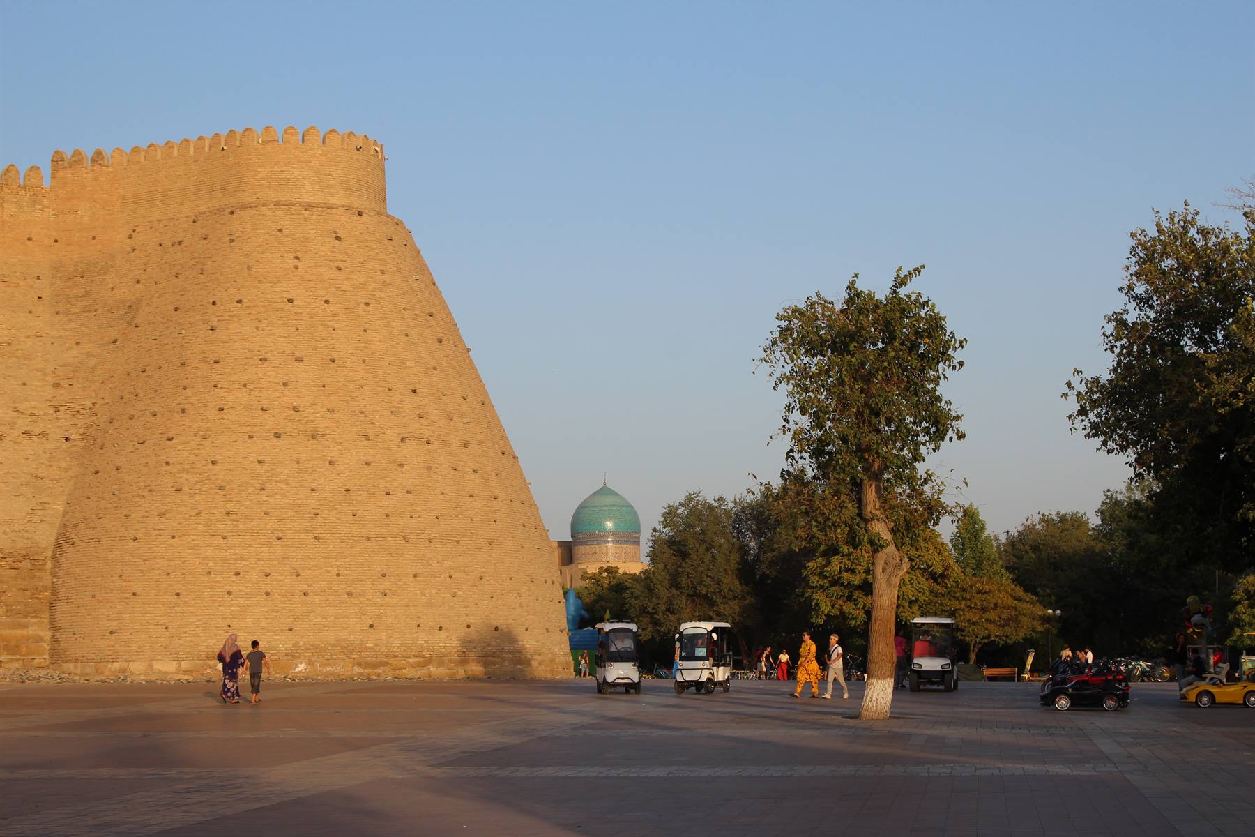 Mura di mattoni di terra alla Registan di Bukhara, navette e passanti