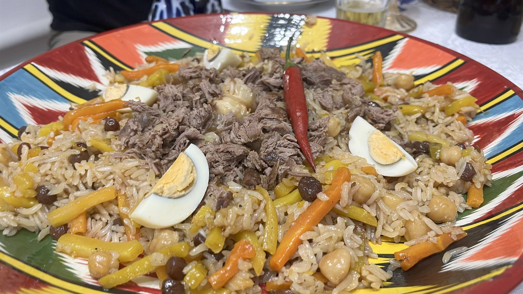 Plov con uova e peperoncino nel piatto decorato tipico di Samarcanda
