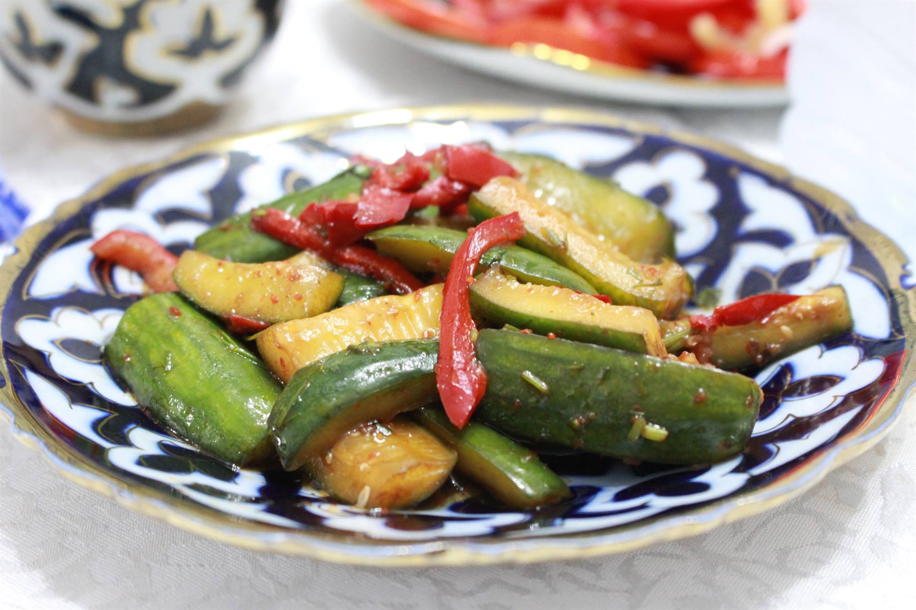 Insalata di cetrioli e peperoni su piatto di ceramica blu di Rishtan