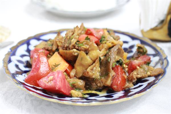 Insalata di melanzane e pomodori su piatto ceramica blu e bianco