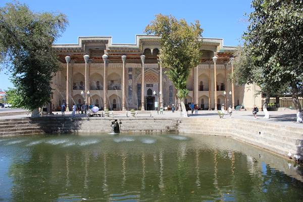 Bukhara: la madrasa si riflette nello stagno sotto il sole