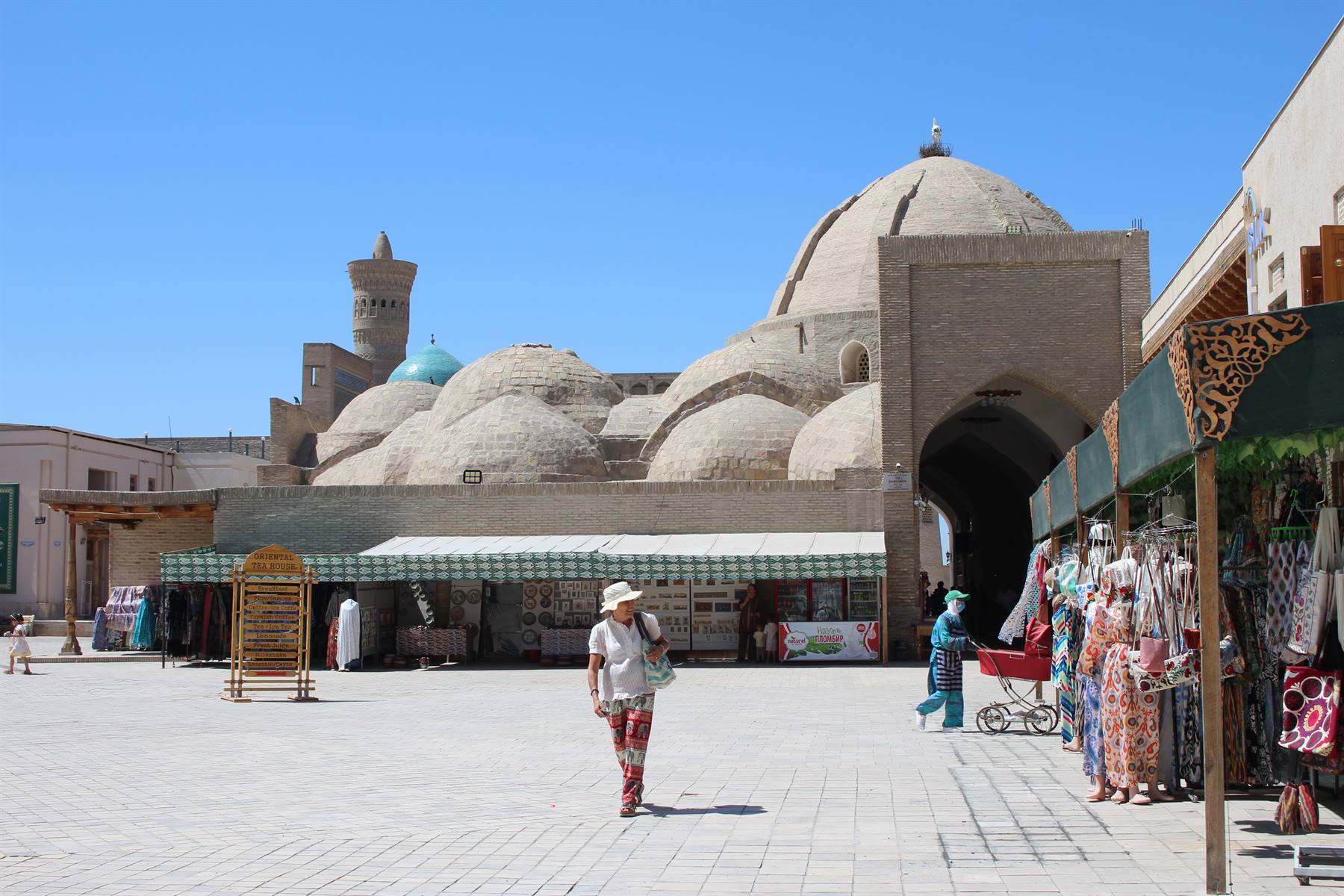 Turista cammina davanti ai banchi di seta del bazar di Bukhara