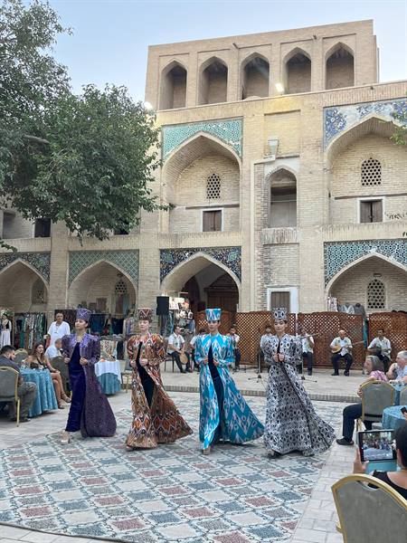 Danzatrici in ikat colorato ballano nel madrasa di Bukhara