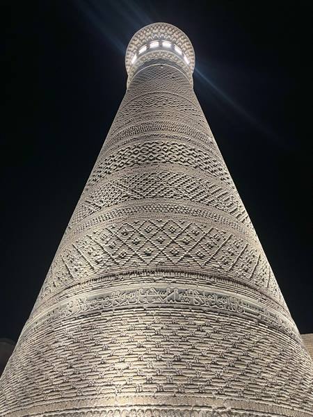 Il minareto Islam Khoja di Khiva, mattoni decorati illuminati nella notte