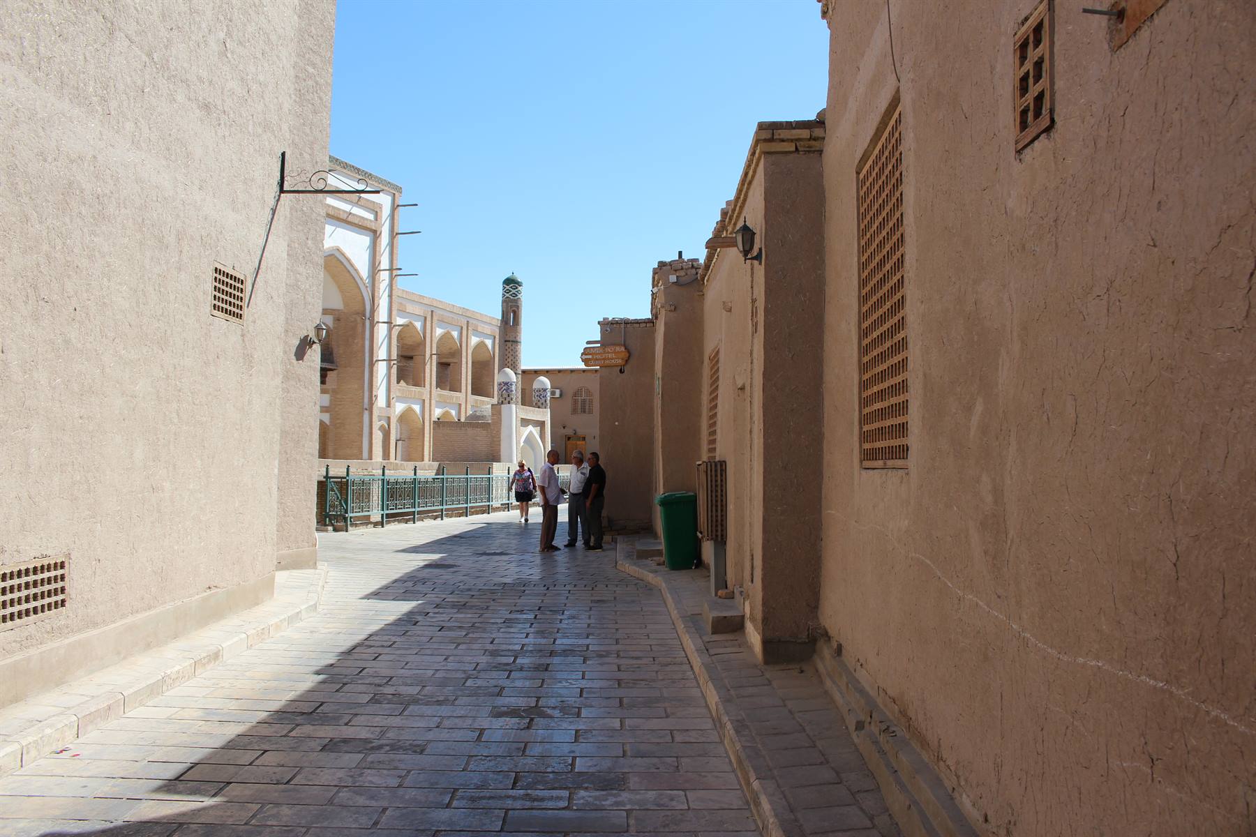Vicolo tra muri di argilla, turisti verso un mausoleo, Khiva