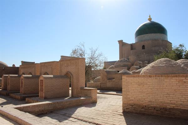 Tombe in mattoni di cotto e cupola verde sotto il sole di Khiva