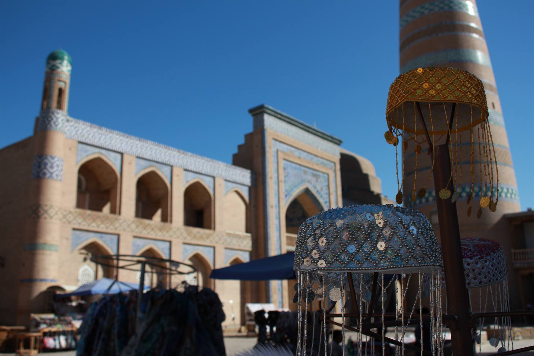 Cappelli ricamati in vendita davanti al minareto di Islam Khoja, Khiva