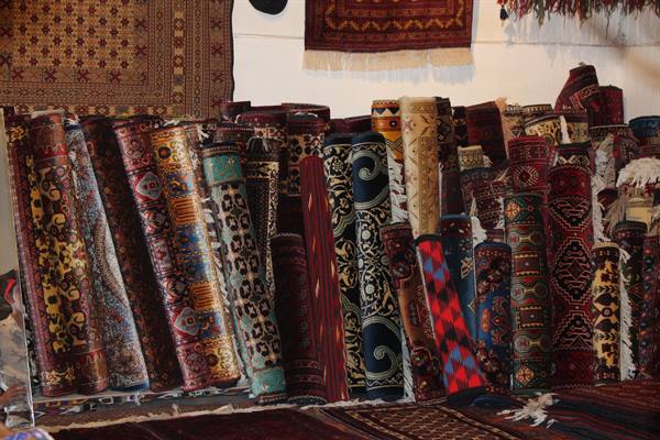 Tappeti arrotolati dai motivi colorati in un bazar di Bukhara