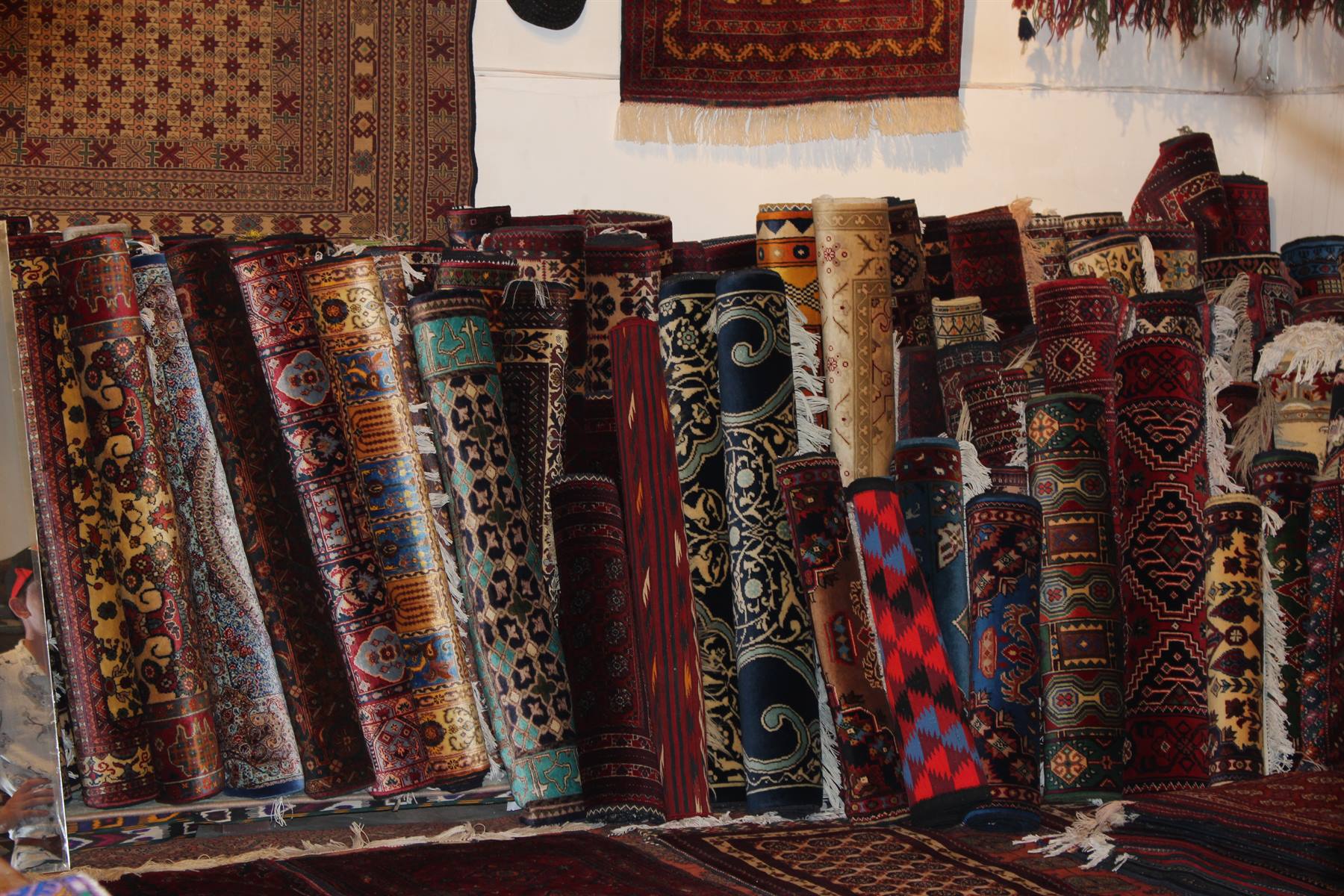 Tappeti arrotolati dai motivi colorati in un bazar di Bukhara