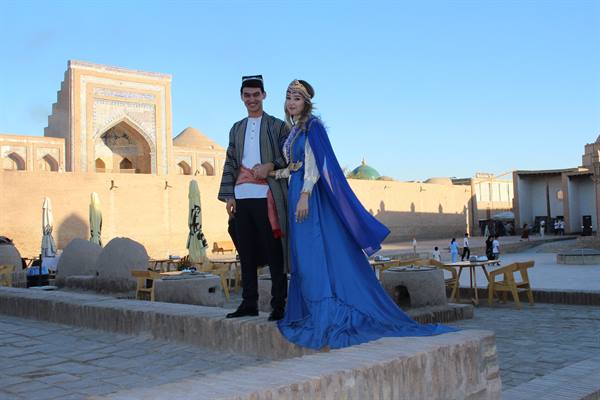 Coppia in abiti tradizionali davanti ai madrasa di Khiva