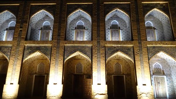 Facciata in mattoni con archi e portali illuminati, madrasa di Khiva
