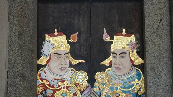 Wooden temple door painted with two golden guardian warriors