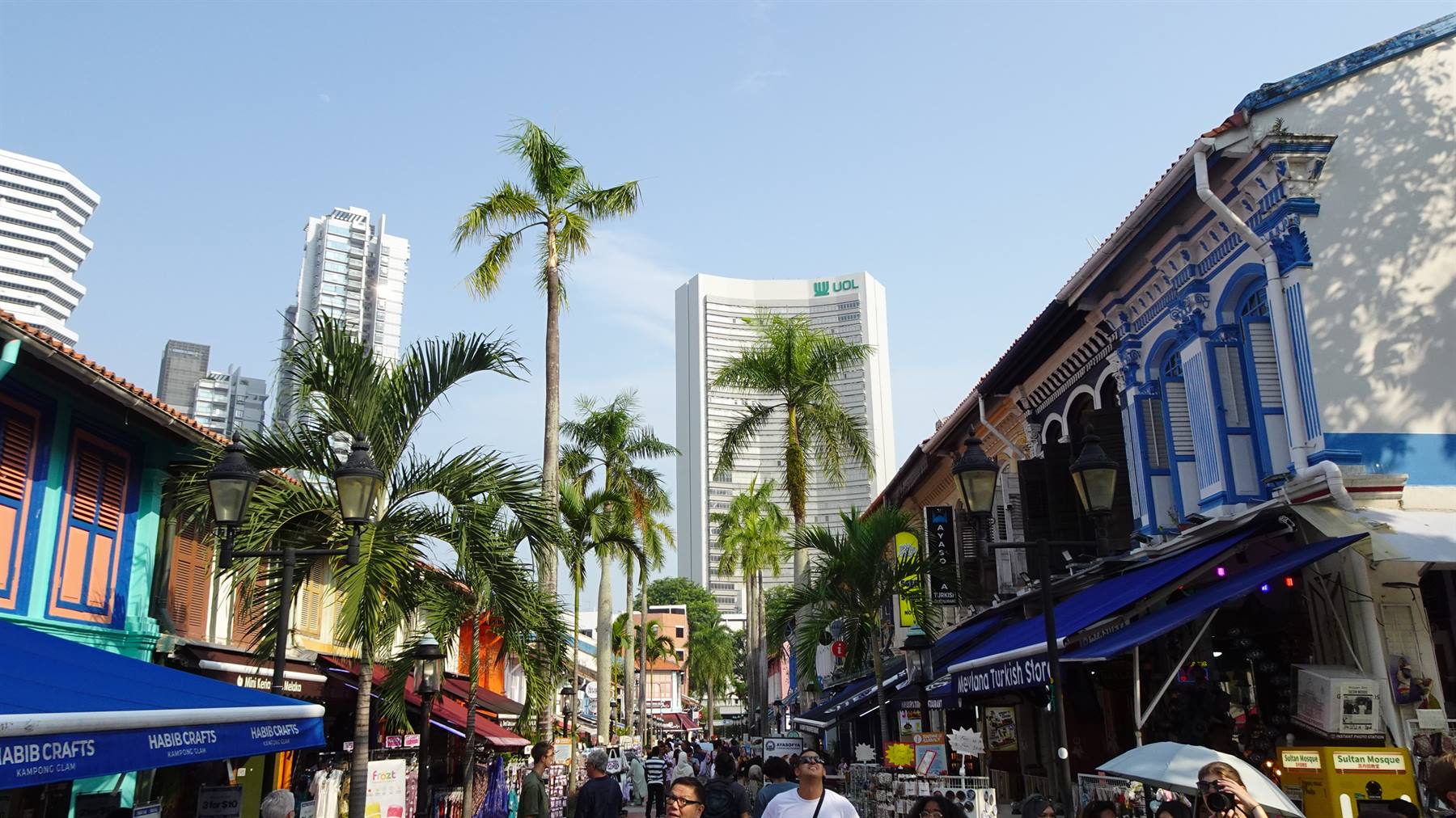 Via pedonale con case colorate e palme, grattacieli sullo sfondo, Singapore