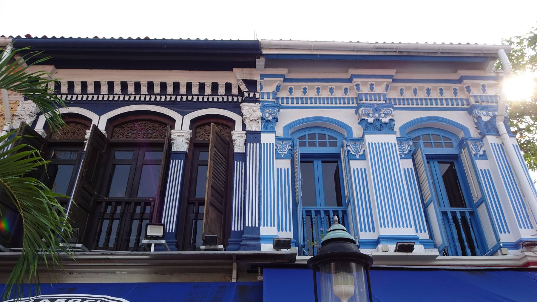 Facciate di case colonnali decorate a strisce blu e bianche, Persone in primera linea