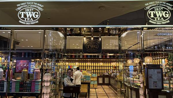 TWG Tea boutique in a shopping mall, golden tea tins, cashier at counter