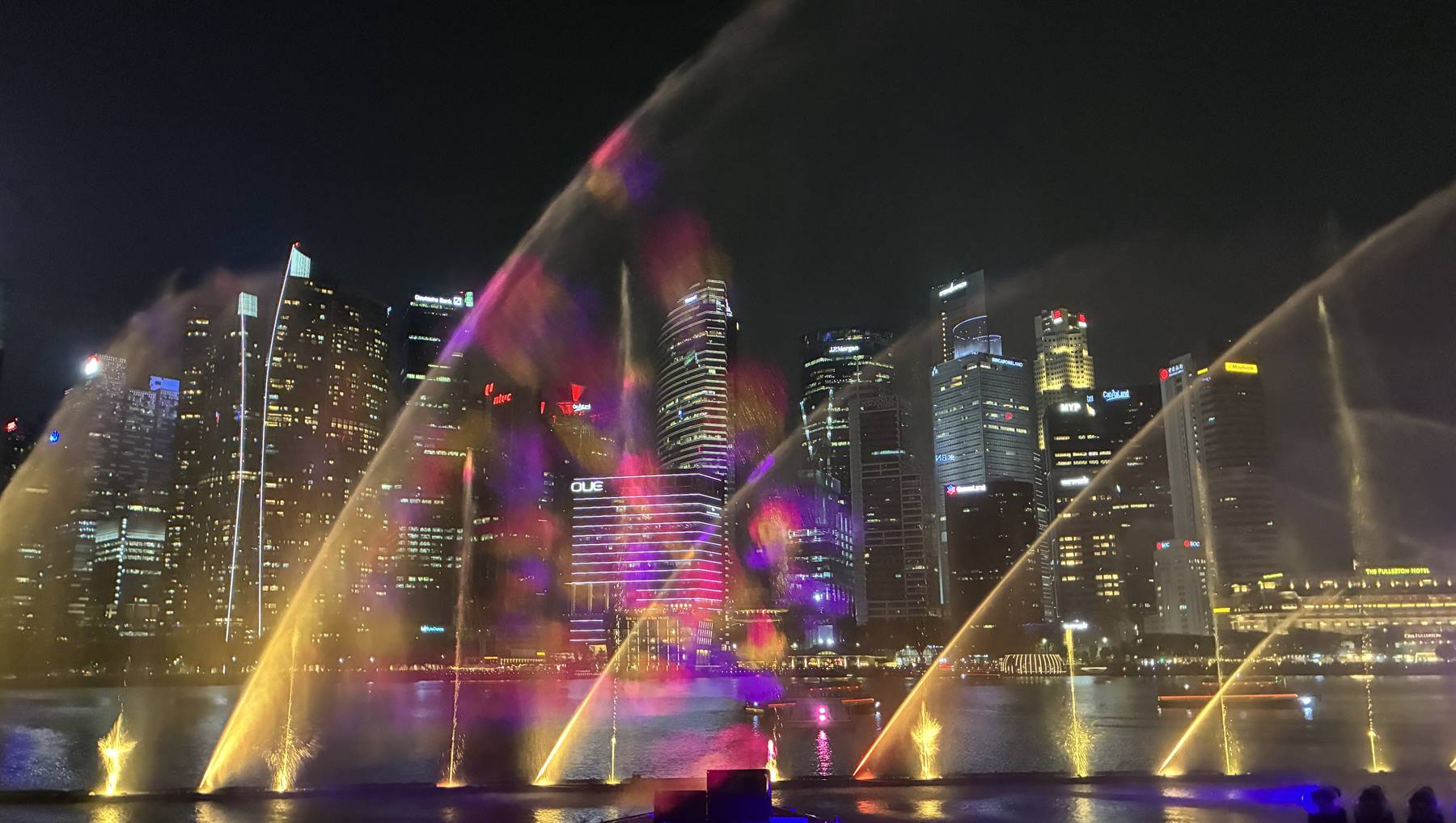 Fontane illuminate che danzano sulla baia davanti ai grattacieli di Marina Bay