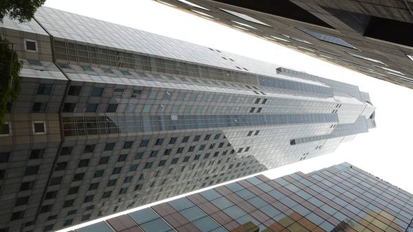 Skyscrapers seen from below, glass and concrete facades against white sky