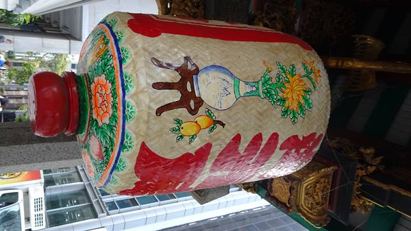 Giant lantern painted with flowers and red characters outside the temple