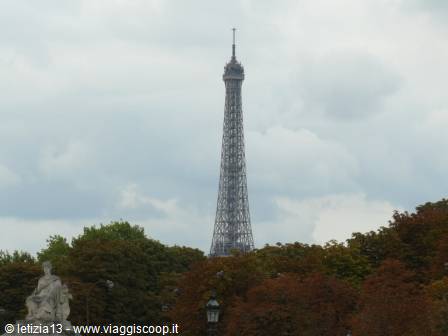 The Eiffel Tower rises among autumn trees above Place du Trocadéro, cloudy sky