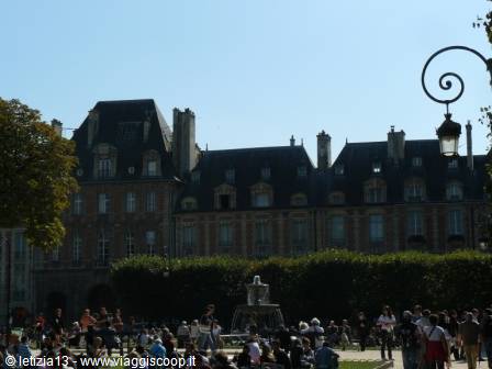 Tourists around the fountain at Place des Vosges, Paris