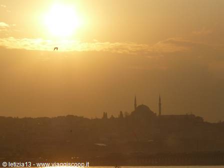 Low sun among clouds, Süleymaniye Mosque silhouette above the buildings