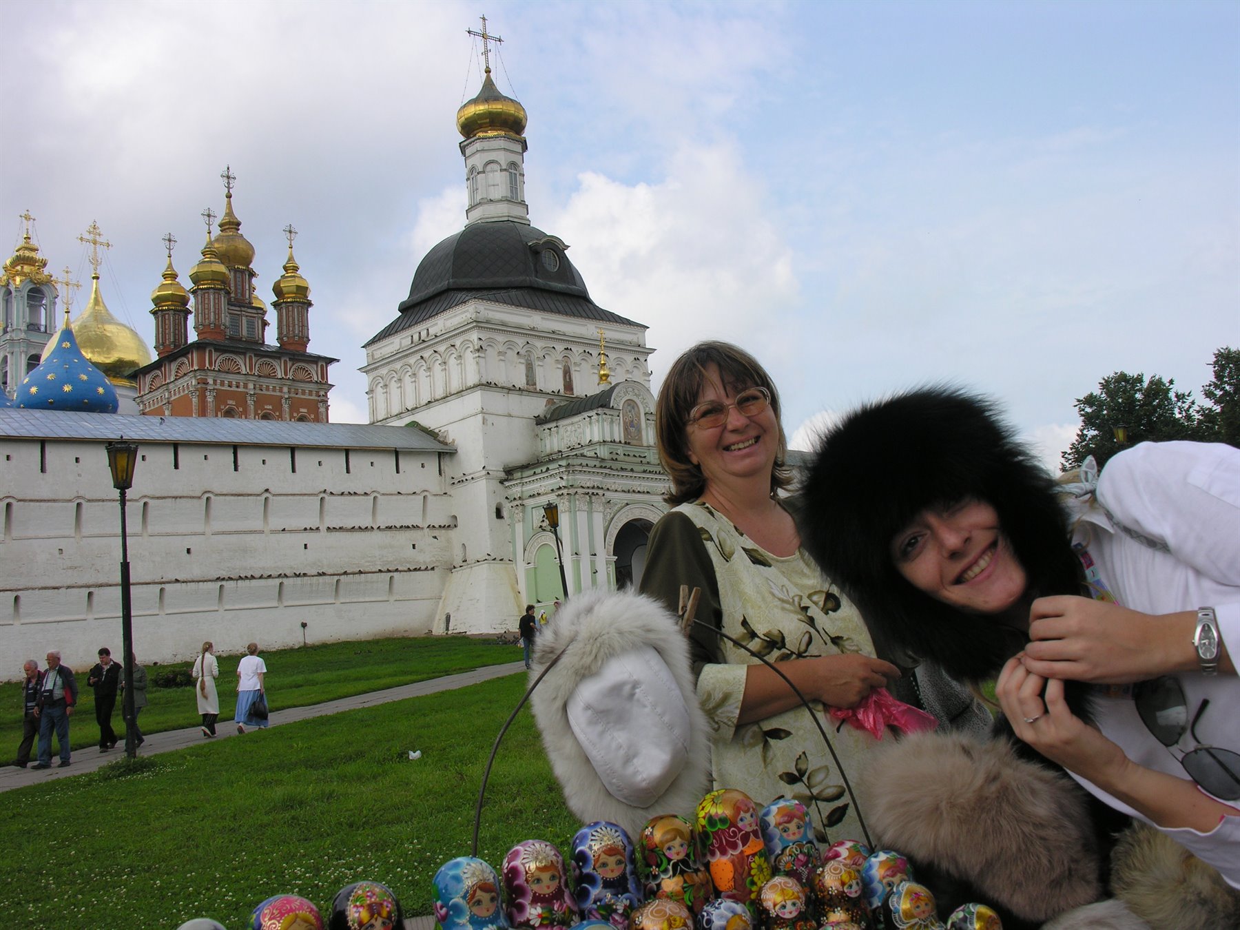 Donne con cappelli di pelliccia e matrioske davanti al monastero di Sergiev Posad