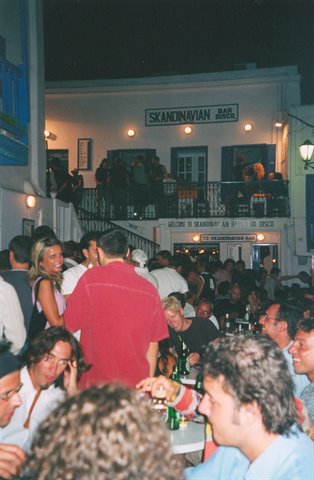 Crowded night scene outside the Skandinavian Bar, people drinking