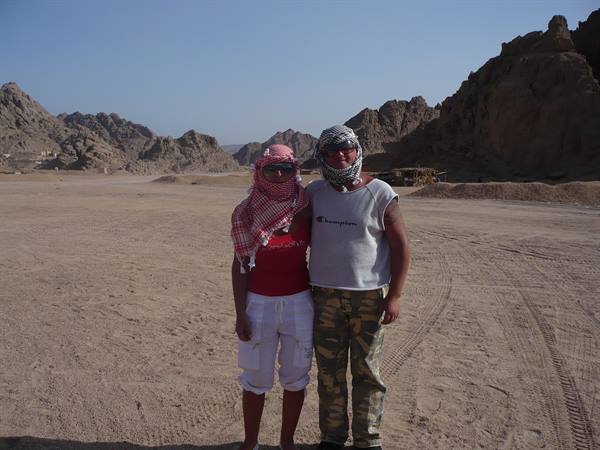 Two tourists wearing keffiyeh in the rocky Sinai desert under the sun