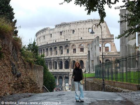Woman walking on cobblestone street in front of the Colosseum in Rome
