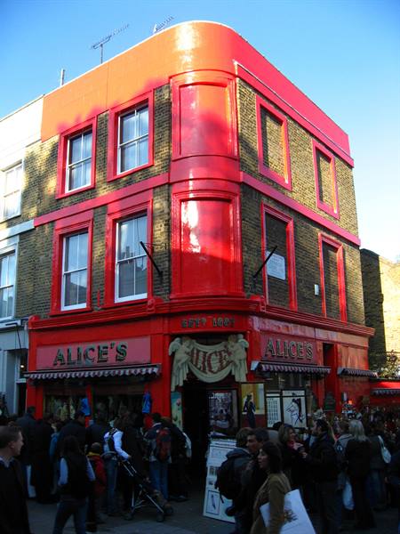 Red Alice's shops on a Portobello Road corner, crowd passing by