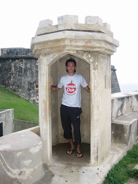 Tourist in Havana Club shirt inside a stone sentry box at El Morro