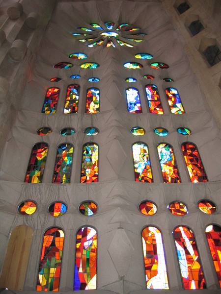 Colorful stained glass windows glowing on the white walls of the Sagrada Família
