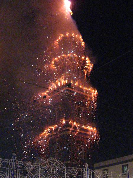Fireworks tower erupts in sparks against the night sky