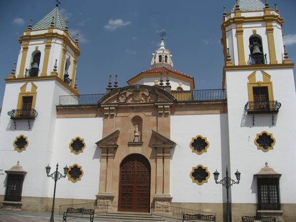 White and ochre church with twin bell towers, bells and stone portal, Ronda