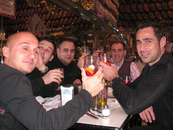 Group of friends toasting with sangria and beers at a bar table