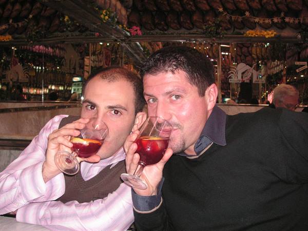 Two men toasting with sangria in a bar decorated with flowers