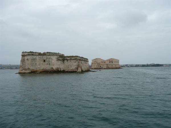 Stone fortress and lazaret in Syracuse harbor, overcast grey sky