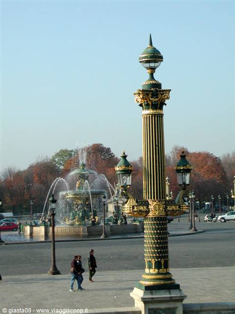 Ornate green and gold lamp post at Place de la Concorde, fountain spraying water
