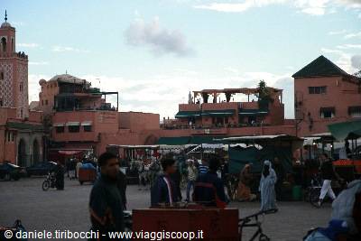 Jemaa el-Fna square in Marrakech, red buildings, minaret and food stall