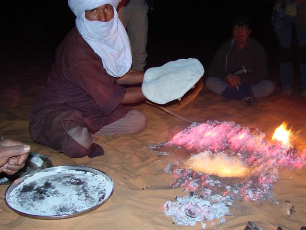 preparation of the Taajeelah- bread baked under the sand
