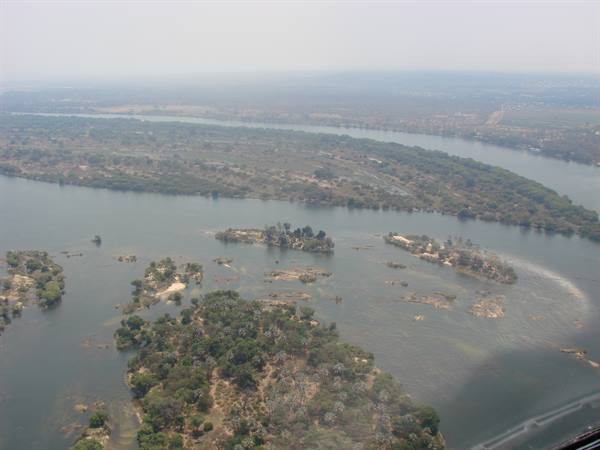 Aerial shot of sandy wooded islands in the Zambezi river under hazy light