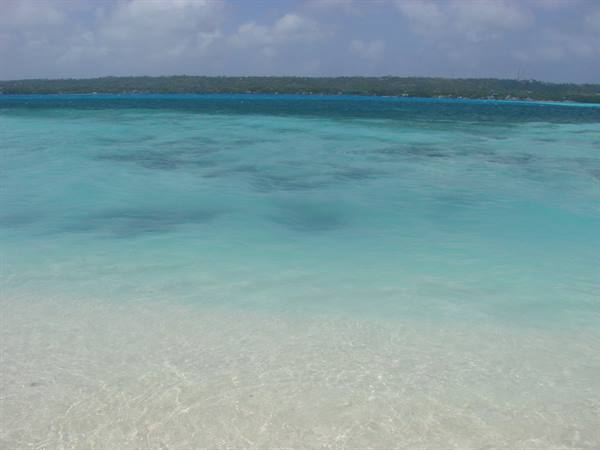 Clear turquoise water over white sand, sunny tropical coastline