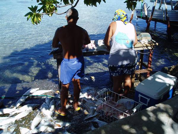 Glorine and family clean the fish for dinner