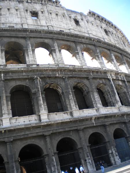 The Colosseum in Rome: travertine arches and tourists under the facade