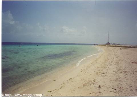 White sand beach with turquoise sea and radio antenna on the coast