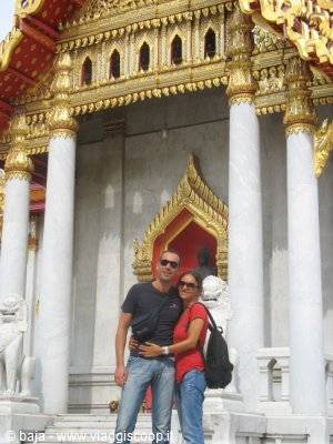 Tourist couple posing in front of the marble temple Wat Benchamabophit, Bangkok
